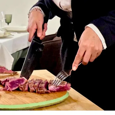 Las manos de Corina cortando la carne sobre la tabla