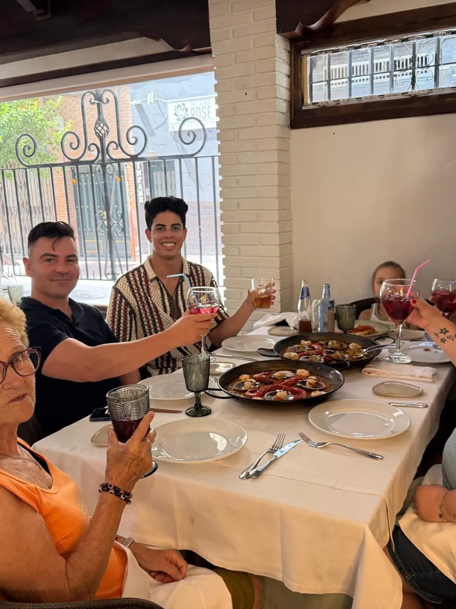 Un grupo brindando en una mesa del salón con platos para compartir